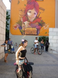 Belly dancer with graffiti wall behind. Graffiti is ubiquitous in Santiago.